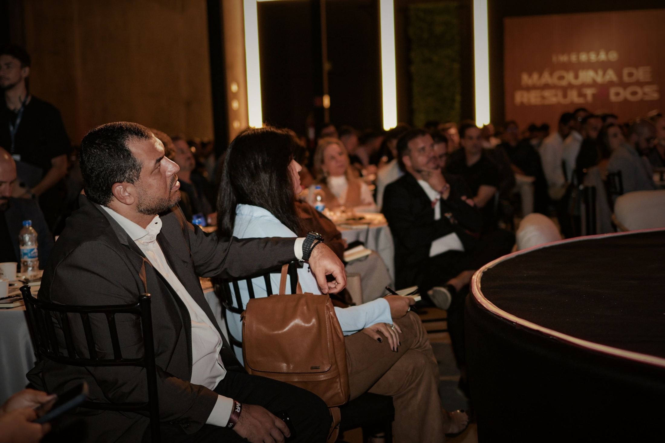 Empresários na plateia de um evento da Enjoy